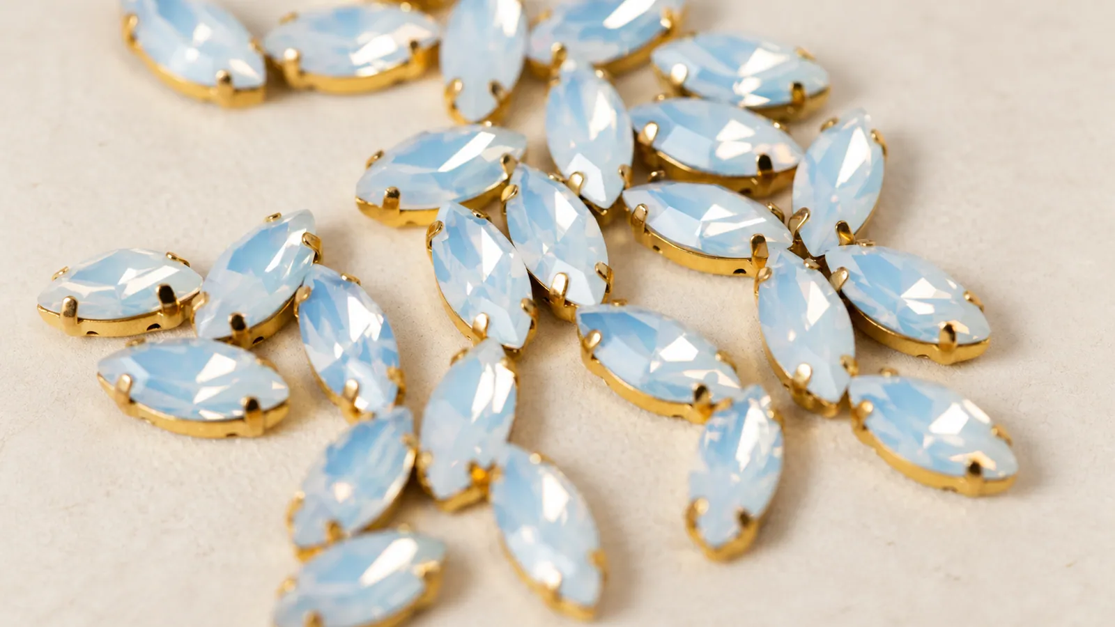 Opal Marquise Rhinestones. Pale ice-blue marquise-shaped stones in warm-tone claw settings. Source-based AI-edited visualization.