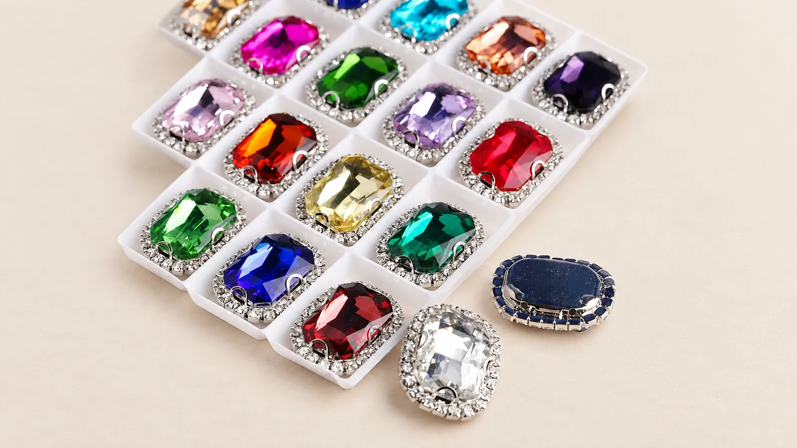 Rectangular Claw Rhinestones. Rectangular jewel-color stones with bright perimeter settings in a sample tray. Source-based AI-edited visualization.